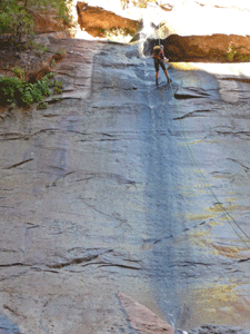 Hiker repelling down waterfall The Narrows Zion