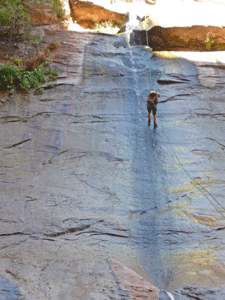 Hiker repelling down waterfall The Narrows Zion