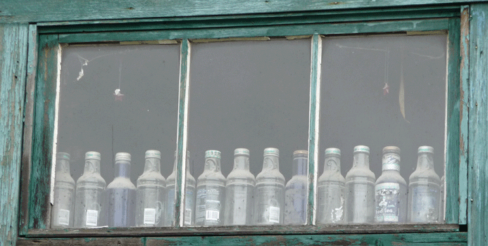 Bottles in window of Chtina Emporium Chitina AK