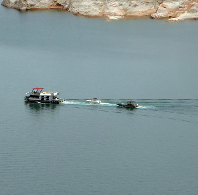 Houseboat with 2 boats in tow