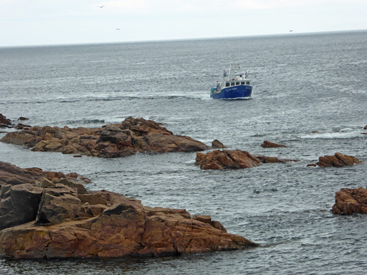 Lobster boat threading rocks