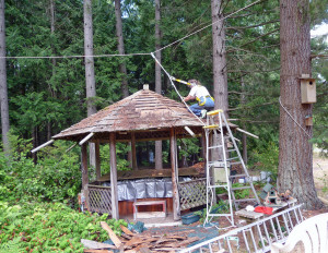 Sara Schurr taking shingles off roof of gazebo