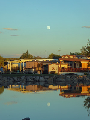 Almost full moon reflected in lake