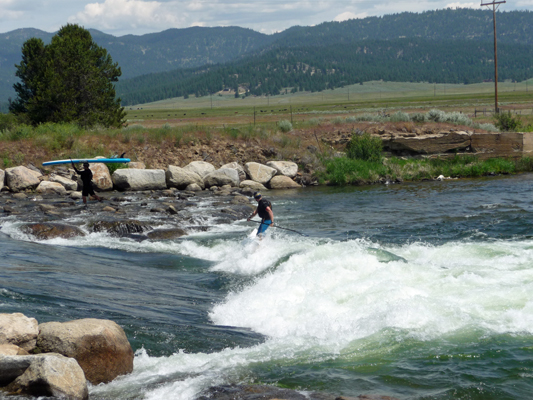 Stand up boarder across rapid Kellys whitewater park ID