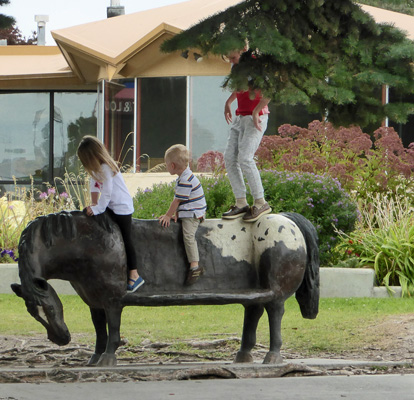 children riding horse-bench